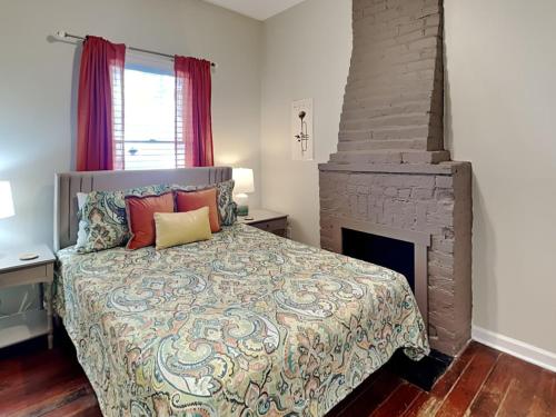 a bedroom with a bed and a fireplace at Barnard Row 1406 in Savannah