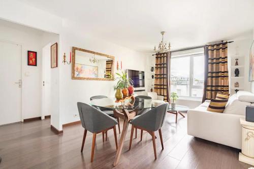 a living room with a table and a couch at Chambres privées, au cœur des sites olympiques in Saint-Denis