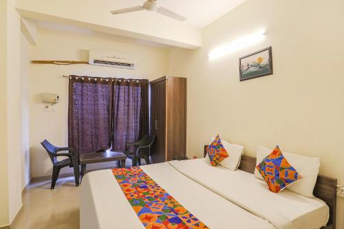- une chambre avec un lit, une chaise et une fenêtre dans l'établissement FabHotel Seva Service Apartment, à Nagpur