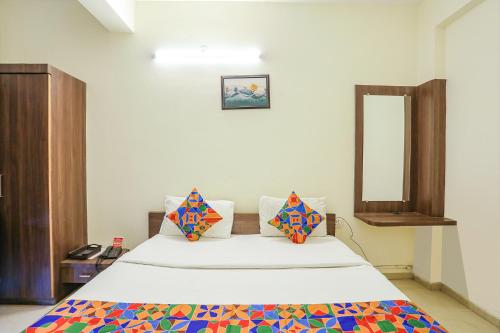 1 dormitorio con 1 cama grande y espejo en FabHotel Seva Service Apartment, en Nagpur
