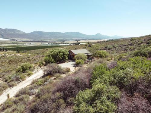 ein Haus auf einer unbefestigten Straße mitten auf einem Feld in der Unterkunft Wolfkop Nature Reserve in Citrusdal