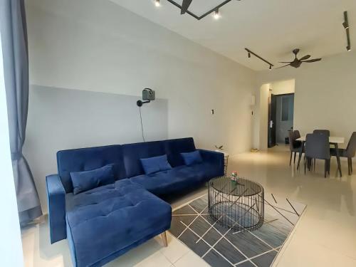 a living room with a blue couch and a table at The Cove Hillside Residence Ipoh in Ipoh