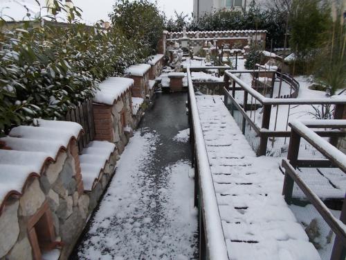 a stream in a garden covered in snow at B&B Il Giardino Acquatico in Coppito