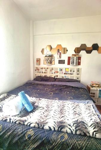 Ganga Room 1 في بلباو: غرفة نوم مع سرير وبطانية حمار الوحشي