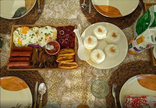 un tavolo con un piatto di cibo con uova e salsicce di Villa Kulintang a Donsol