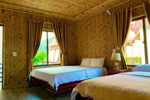 a bedroom with two beds and a window at The Pineapple House in Ninh Binh