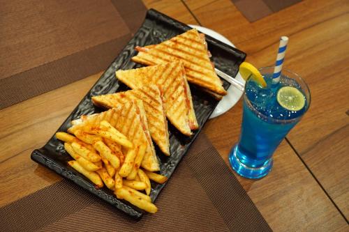 a plate of food with chips and a drink at The Neeraj Naturecure On Ganga in Rishīkesh