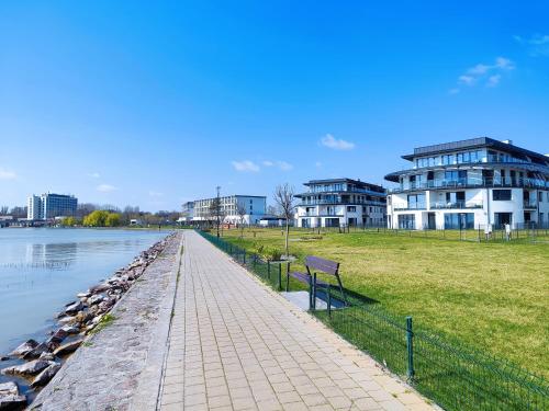 a walkway next to a river with buildings and birds at Royal Martin's Apartment in Keszthely