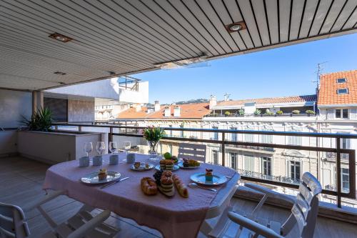 - une table sur un balcon avec vue sur la ville dans l'établissement Residence Gray d'Albion 2P BLA584, à Cannes