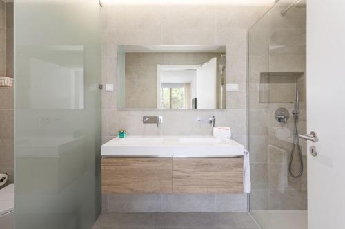 a bathroom with a white sink and a mirror at Hopstays - Vila das Lagoas - Salgados in Albufeira