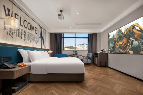 Pokój hotelowy z łóżkiem i biurkiem w obiekcie Mehood Hotel Huangshan High-Speed North Station w mieście Huang Shan
