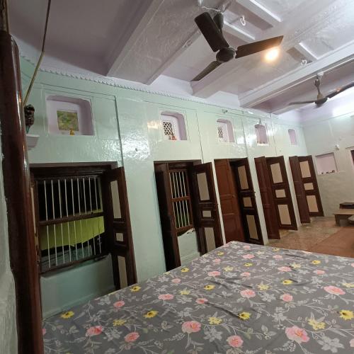 a room with a bed and a row of doors at Feel Aesthetic Kashi Home Stay in Varanasi