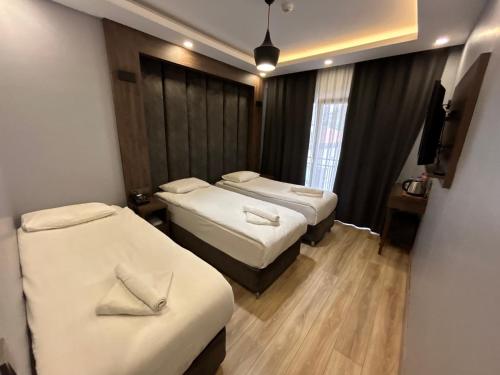 a hotel room with two beds and a window at Basilissis Hotel in Istanbul