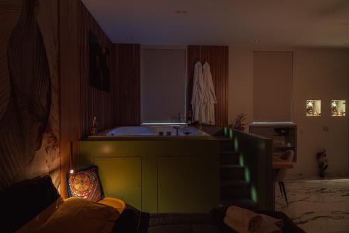 a living room with a couch and a bath tub at Ortigia Sitari suites in Siracusa