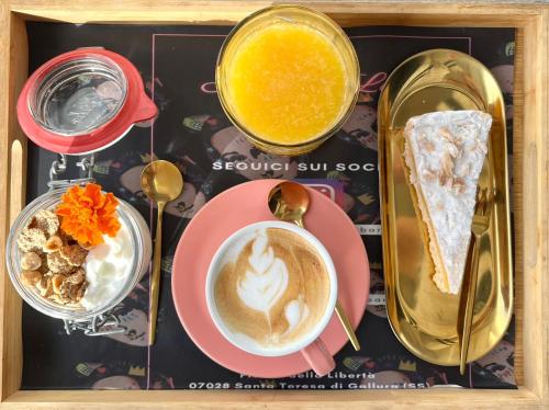 una foto di un vassoio di cibo e di una tazza di caffè di Tramonto sul mare a Santa Teresa di Gallura
