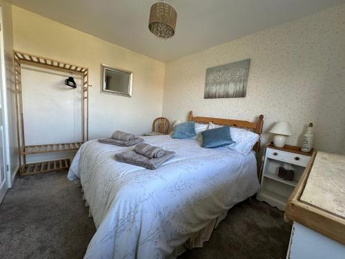 a bedroom with a bed with blue pillows on it at 2-Bed Apartment in Coleshill in Birmingham