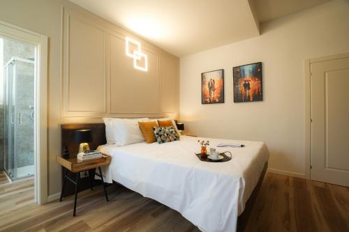 a bedroom with a large white bed and a table at Mazzini's Rooms in Modena
