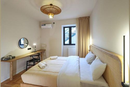 um quarto com uma cama grande e uma secretária em Newly Designed 2BR Apartment In Center-By Wehost em Tbilisi