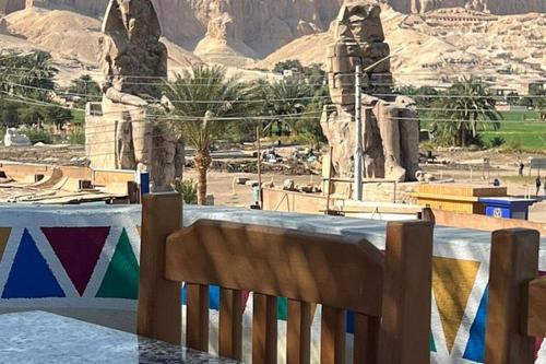 a wooden chair sitting in front of a statue at luxo bankr west in Luxor
