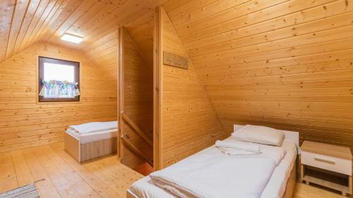 a room with two beds in a wooden cabin at Apartamenty Sun & Snow Nowodworska in Stegna