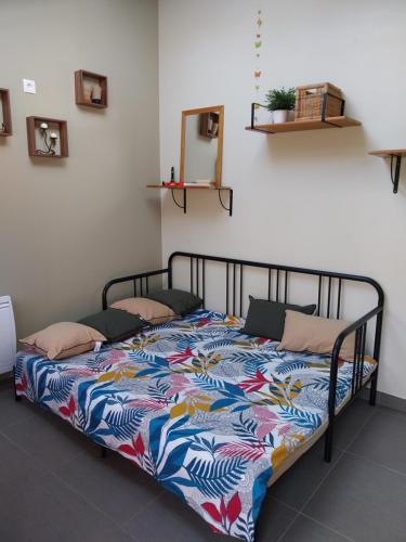 a bed with a colorful quilt on it in a room at le prieuré reposant in Notre-Dame de la Mer