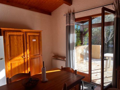 a dining room with a table and a sliding glass door at l'Espinet Vacances in Quillan