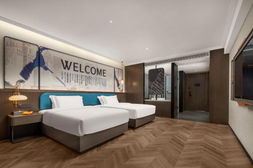 a hotel room with a bed and a television at Mehood Hotel Huangshan High-Speed North Station in Huangshan