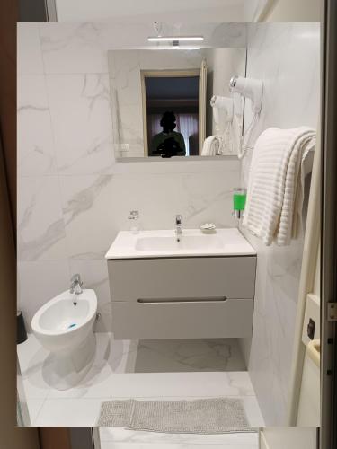a white bathroom with a sink and a toilet at Hotel Centrale Europa in Catania