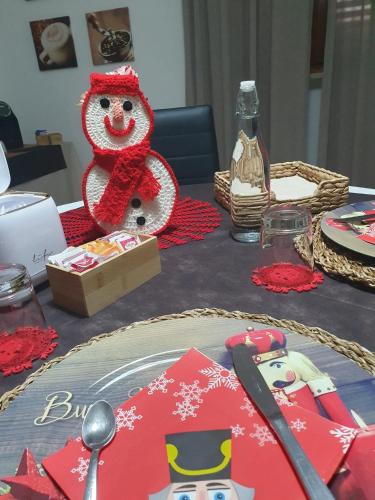 a table topped with a cake with a snowman on it at La casa dei nonni in San Salvo