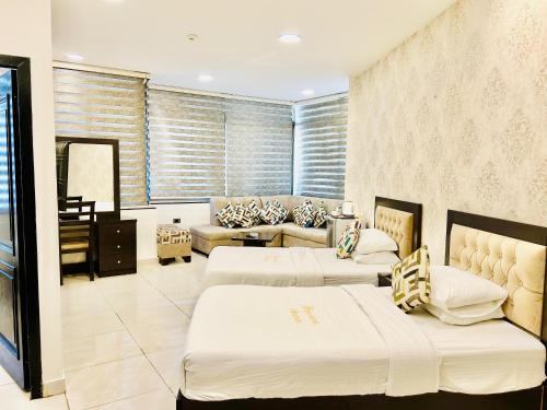 een woonkamer met twee bedden en een bank bij Panorama Amman Hotel in Amman