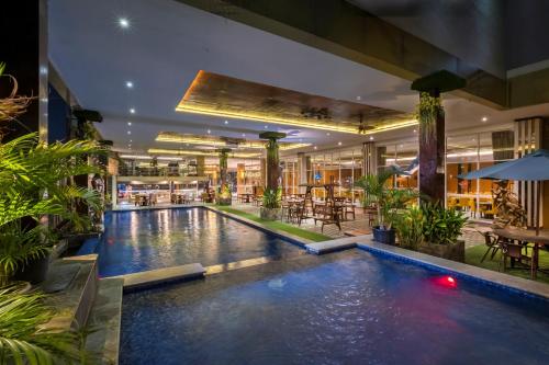 a large swimming pool in a building with plants at Gets Hotel Semarang in Semarang