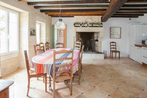 une salle à manger avec une table et une cheminée dans l'établissement Maison La Fleur Godard - Clos Fontaine, à Saint-Cibard