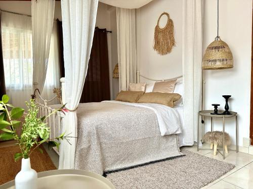 a bedroom with a white bed and a table at Anerada Cottages in Apsiou