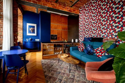 a living room with a blue couch and a table at RentPlanet - Nowa Papiernia in Wrocław