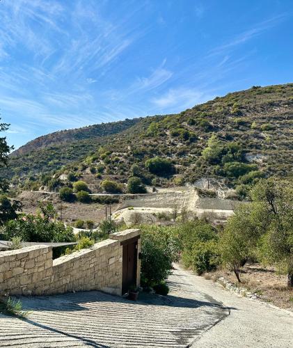 a stone wall with a mountain in the background at Anerada Cottages in Apsiou