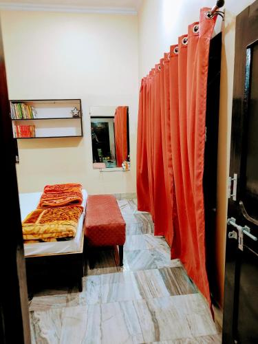 a bedroom with orange curtains and a bed in a room at Shantiniketan 4BHK Comfortable Family Stay in Ayodhya in Ayodhya