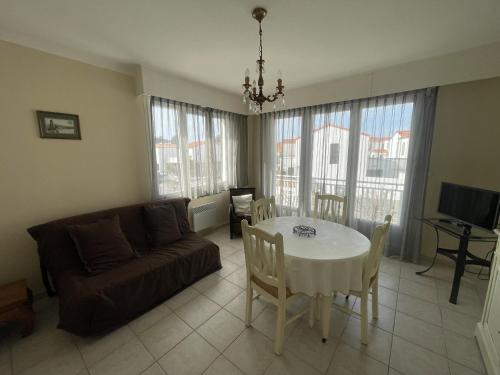 un salon avec une table et un canapé dans l'établissement LS05022 Le Petit Ampère 700m de la plage, à Les Sables-dʼOlonne