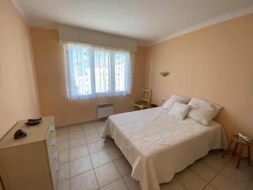 une chambre avec un lit blanc et une fenêtre dans l'établissement LS05022 Le Petit Ampère 700m de la plage, à Les Sables-dʼOlonne