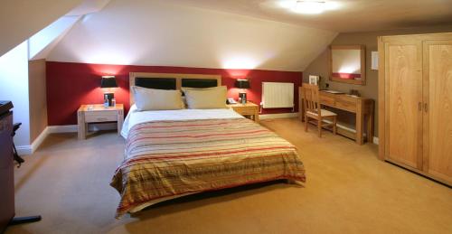 a bedroom with a large bed and a desk at Colwick Hall Hotel in Nottingham