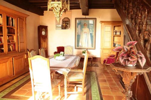 une salle à manger avec une table, des chaises et un lustre dans l'établissement MANOIR DU TERTRE au coeur de la forêt de Brocéliande, à Paimpont