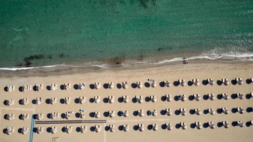 eine Aussicht über den Strand mit einem Haufen Regenschirme in der Unterkunft TUI Magic Life Candia Maris - Adults Only in Ammoudara