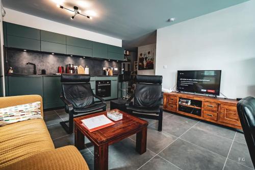 uma sala de estar com duas cadeiras e uma televisão em Le Doran Familial Parking WIFI em Sallanches