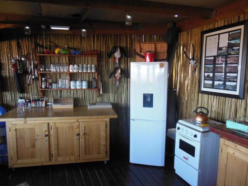 a kitchen with a white refrigerator and a counter at Zandfontein Bush Camp and Game Farm in Platdrift