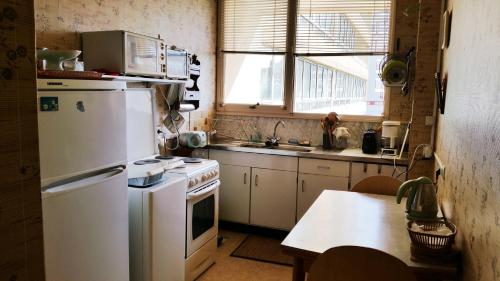 une cuisine avec un réfrigérateur blanc et une table dans l'établissement Appartement charmant centre ville, à Les Sables-dʼOlonne