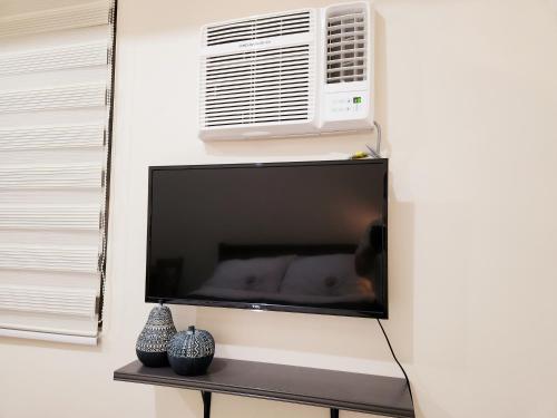 a flat screen tv hanging on a wall at KL Tower Condo, Makati City in Manila