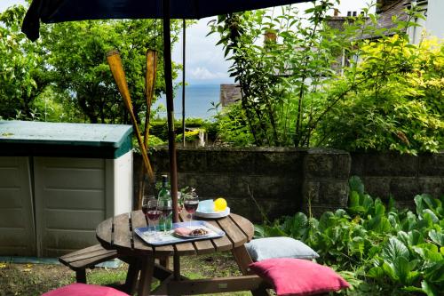 a table and chairs with an umbrella in a garden at Ellesmere New Quay in New Quay