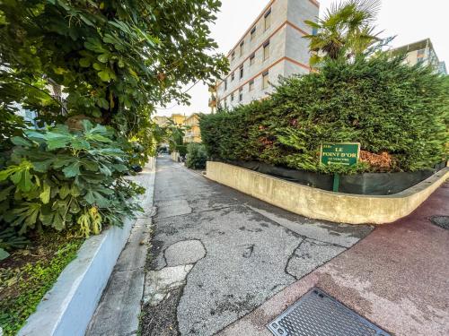 une rue avec des buissons et un panneau sur celle-ci dans l'établissement Cocon Riviera, à Cannes