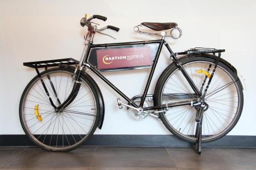 a bike parked next to a wall with a sign at Bastion Hotel Amsterdam Airport in Hoofddorp