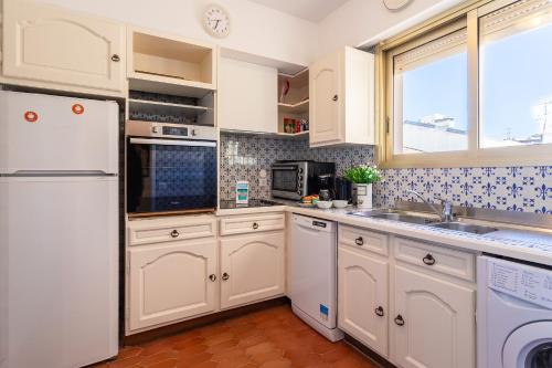 une cuisine avec des appareils électroménagers blancs et une fenêtre dans l'établissement Le Minerve 3P DEB5515, à Cannes