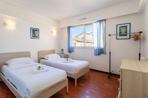 deux lits dans une chambre avec une fenêtre dans l'établissement Le Minerve 3P DEB5515, à Cannes